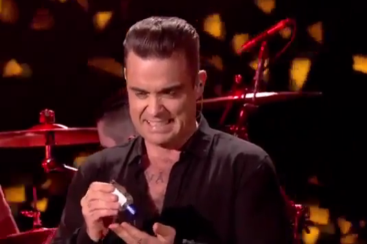 Robbie Williams usa gel antibectarial luego de saludar a fans.