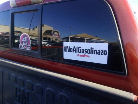 Panistas reparten calcomanías con la leyenda "#No al 'gasolinazo',  #fuera Peña" a automovilistas y les piden que las peguen en sus vehículos. 