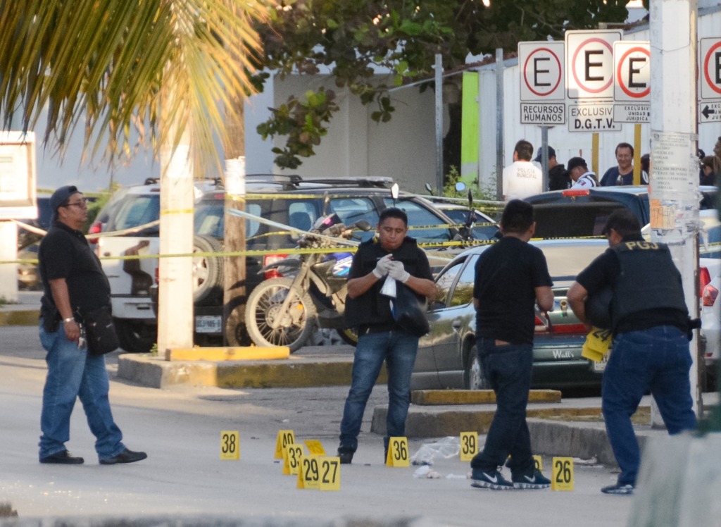 Policías investigadores trabajan en la zona del ataque a la Fiscalía de Quintana Roo, donde se han contabilizado varios cartuchos percutidos.