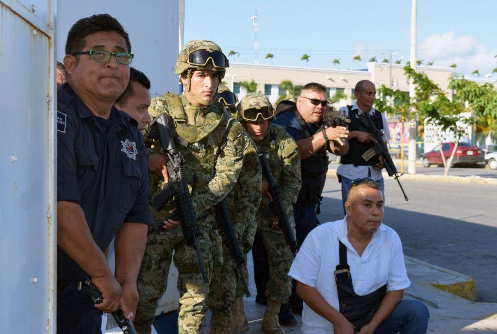 Policías y militares se resguardan en una zona de los balazos contra la Fiscalía de Quintana Roo.