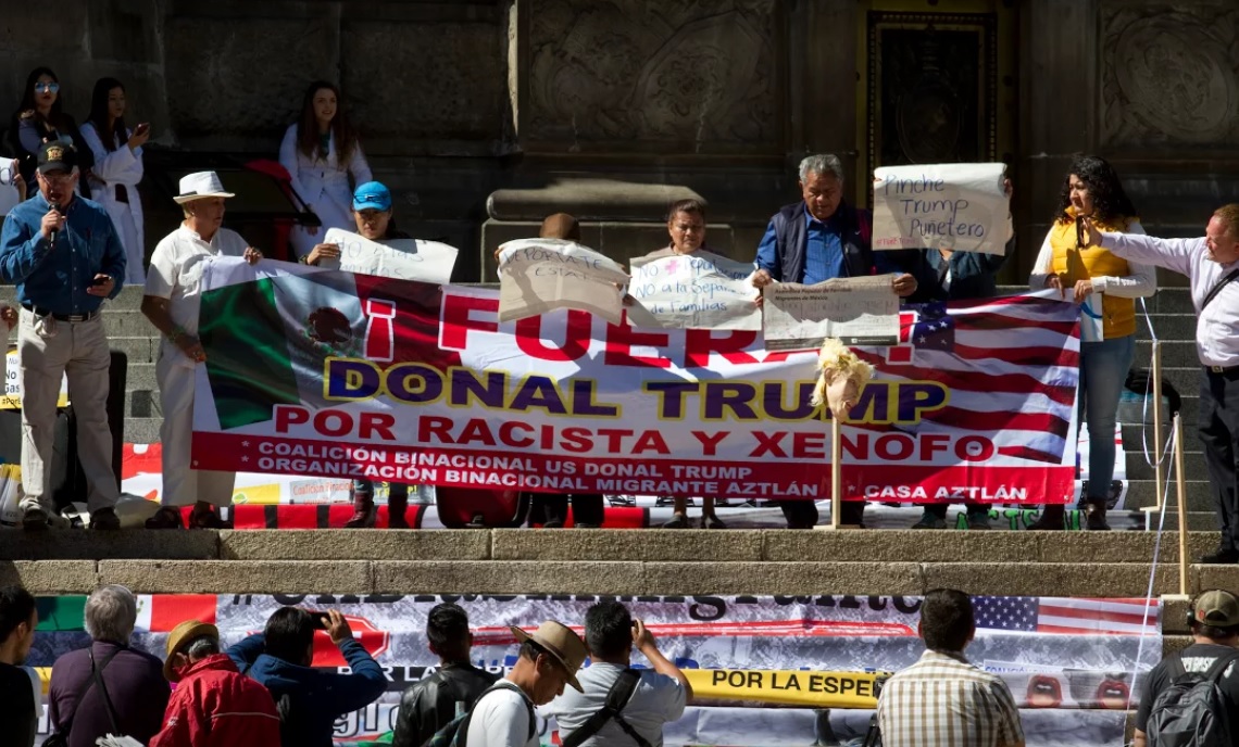 Con pancartas, los manifestantes defienden la dignidad de los migrantes y nombran racista al presidente republicano.