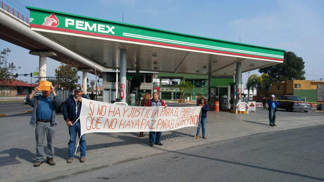Los manifestantes portan pancartas en contra del gobierno. 