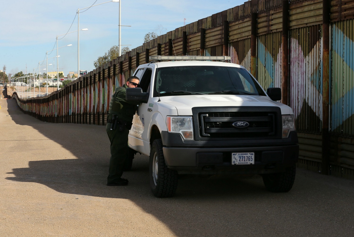 Agentes de la patrulla fronteriza vigilan el muro en la frontera con México.