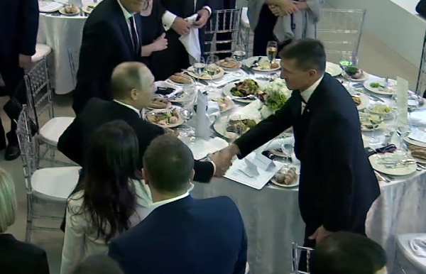 En una imagen tomada de un video del 10 de diciembre de 2015 se ve Michael Flynn saludando a Vladimir Putin en Moscú.