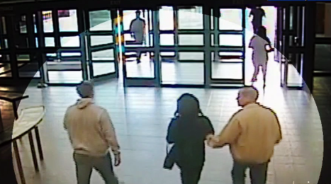 Dos agentes de ICE conducen a Irvin González afuera del juzgado.