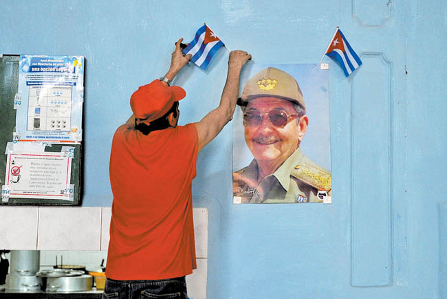 Un habitante de La Habana coloca una foto del mandatario en su negocio. 