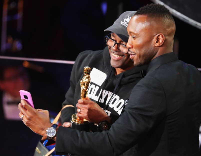 Un fan posa junto con Mahershala Ali y su Oscar.