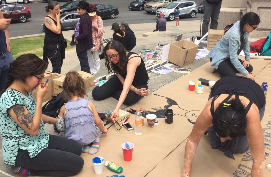 Las participantes realizan pancartas con mensajes contra la violencia hacia las mujeres.