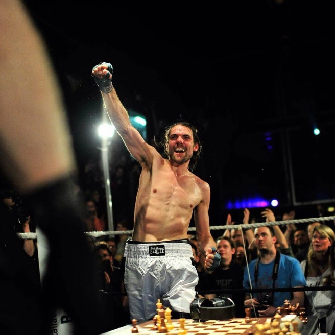 Boxeador celebra su triunfo en tablero de ajedrez