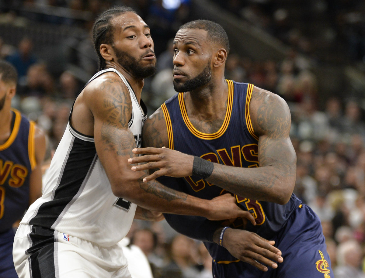 Kawhi Leonard disputa un balón con LeBron James