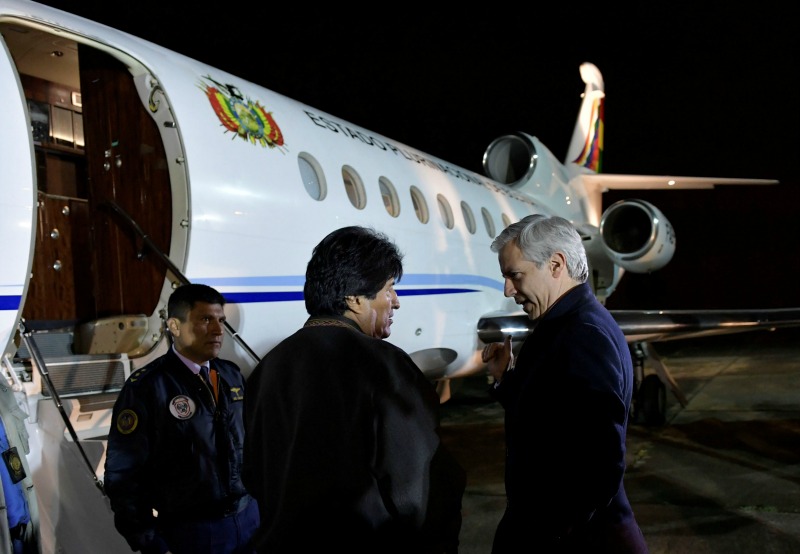 Morales conversa con su vicepresidente Álvaro García Linera antes de abordar el avión presidencial que lo llevará a Cuba.