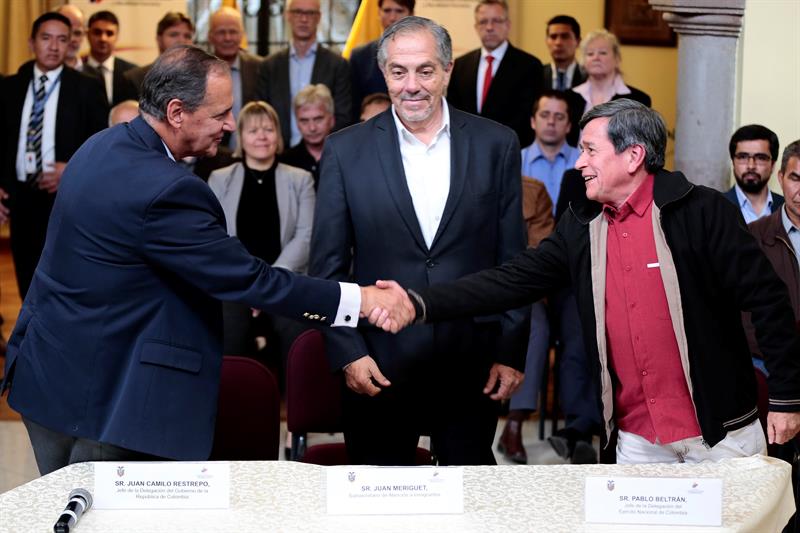Los jefes negociadores del gobierno, Juan Camilo Restrepo (c-i), y del ELN, Pablo Beltrán tras el anuncio.