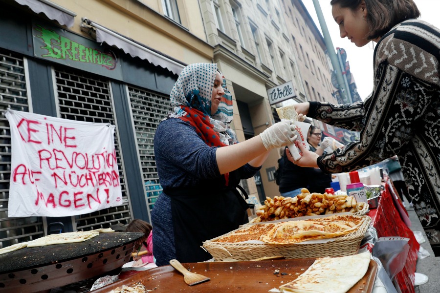 "No hay revolución con el estómago vacío", dice un cartel junto a unos puestos de comida durante la celebración del Día del Trabajo en la capital alem