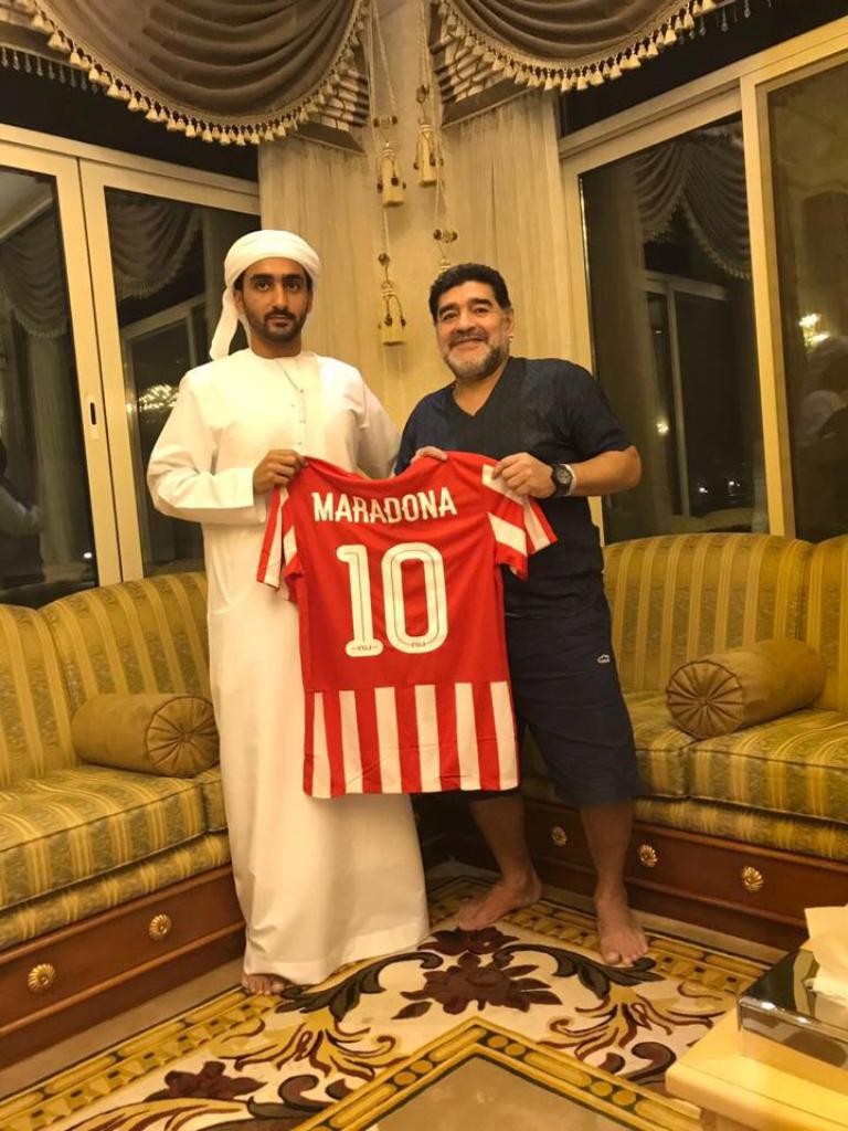 Maradona mostrando la playera del nuevo club que dirigirá en Emiratos Árabes
