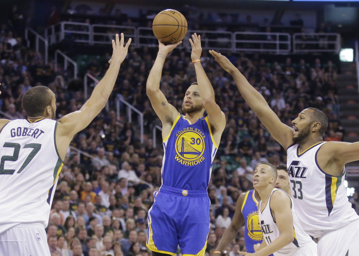 Stephen Curry lanza ante la defensa de Rudy Gobert y Boris Diaw