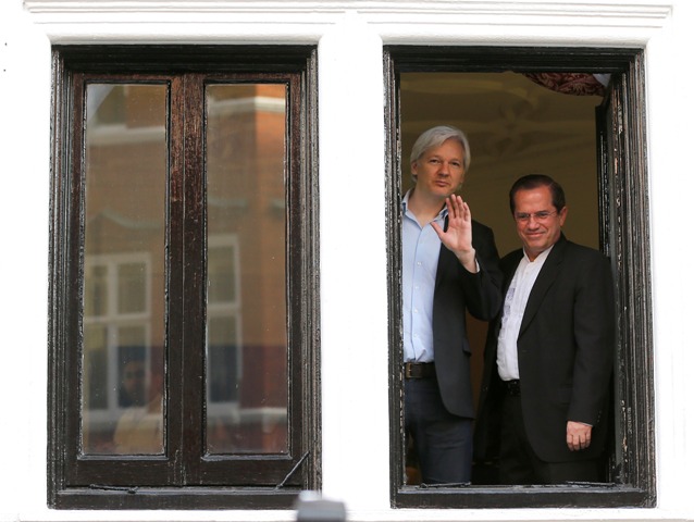 Julian Assange saluda desde la embajada de Ecuador en Londres, en 2013.
