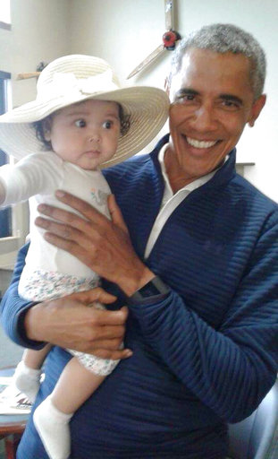 Barack Obama carga a la pequeña Giselle, de seis meses.
