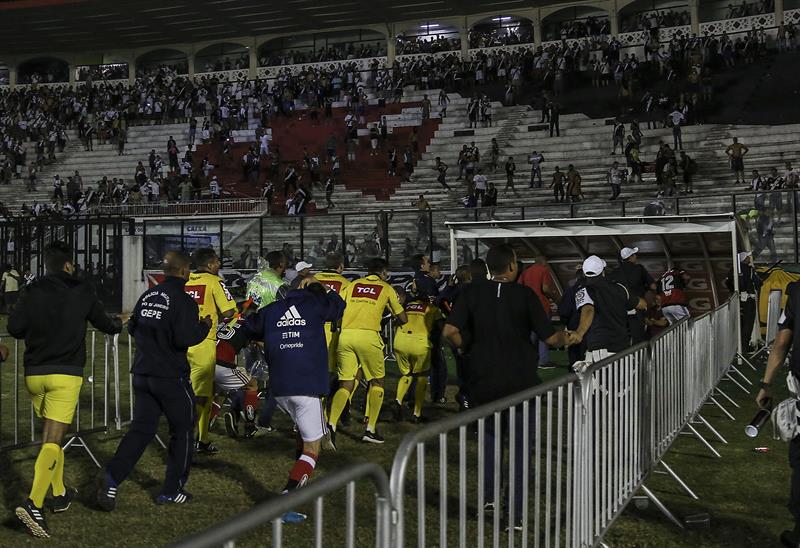 Los jugadores de Flamengo y los jueces del partido buscan refugio en los vestidores por los gases lacrimógenos que lanzó la policía contra los aficion