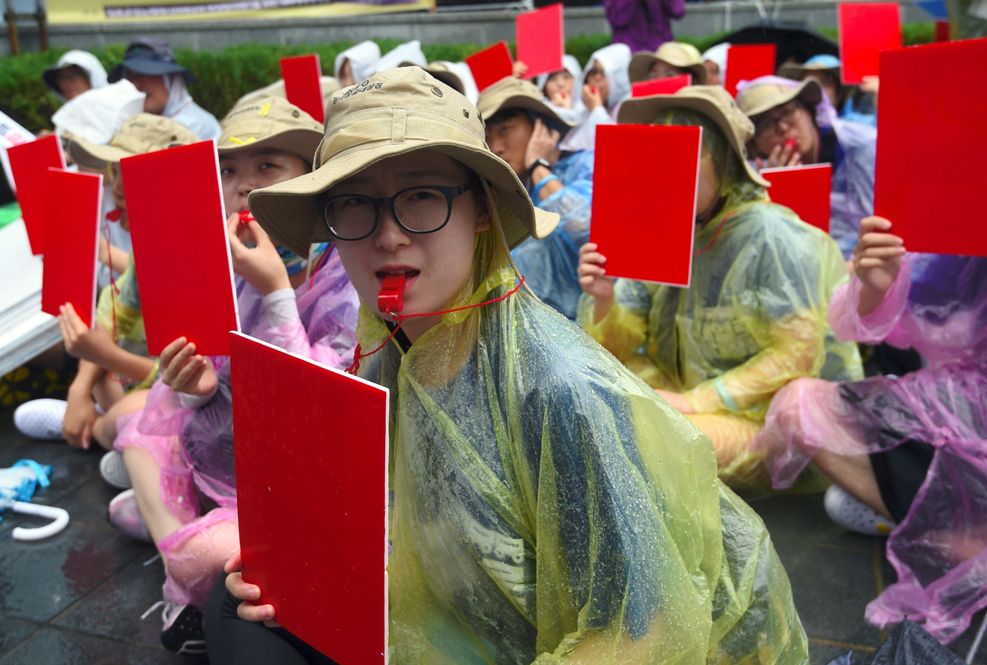 Algunas personas sostenían cartones de color rojo como símbolo para que Corea del Sur suspenda su cooperación militar con Japón.
