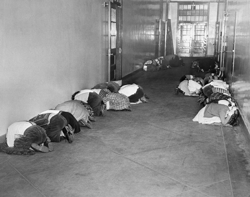 Esta foto tomada el 25 de enero de 1951, los estudiantes de la escuela primaria Thomas Jefferson se arrodillan en el pasillo durante un simulacro de a