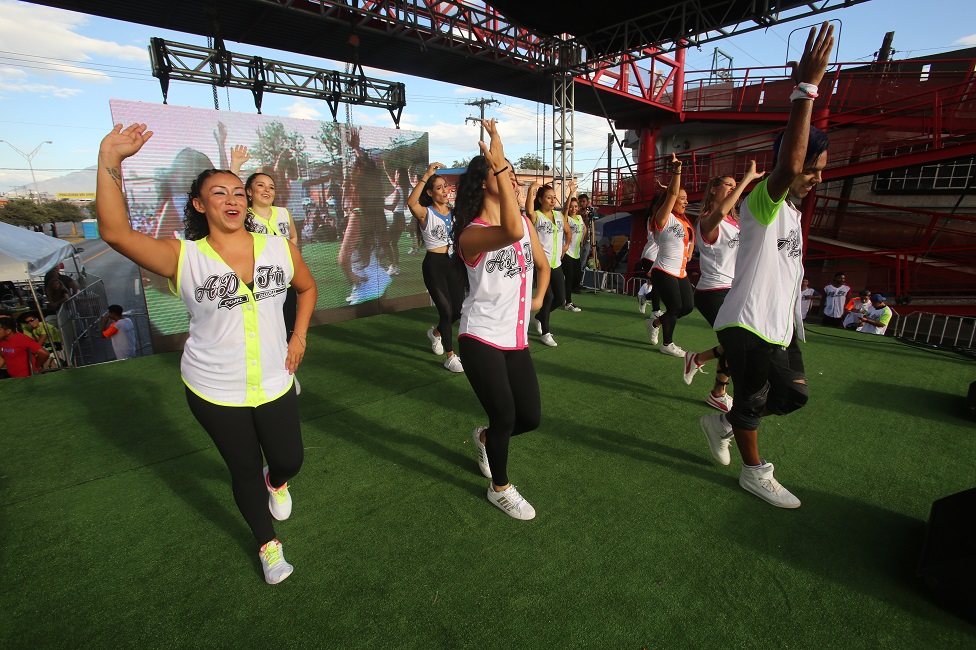 En el escenario se encontraban bailarines dirigiendo a los asistentes en la coreografía.