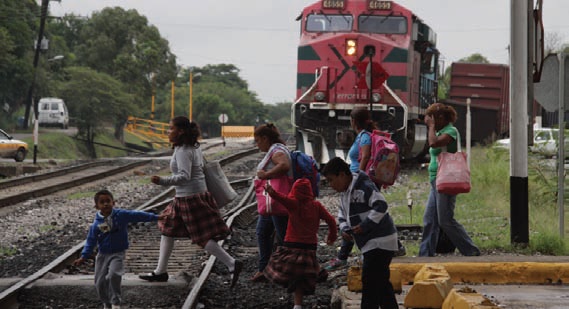Personas cruzando las vías férreas.