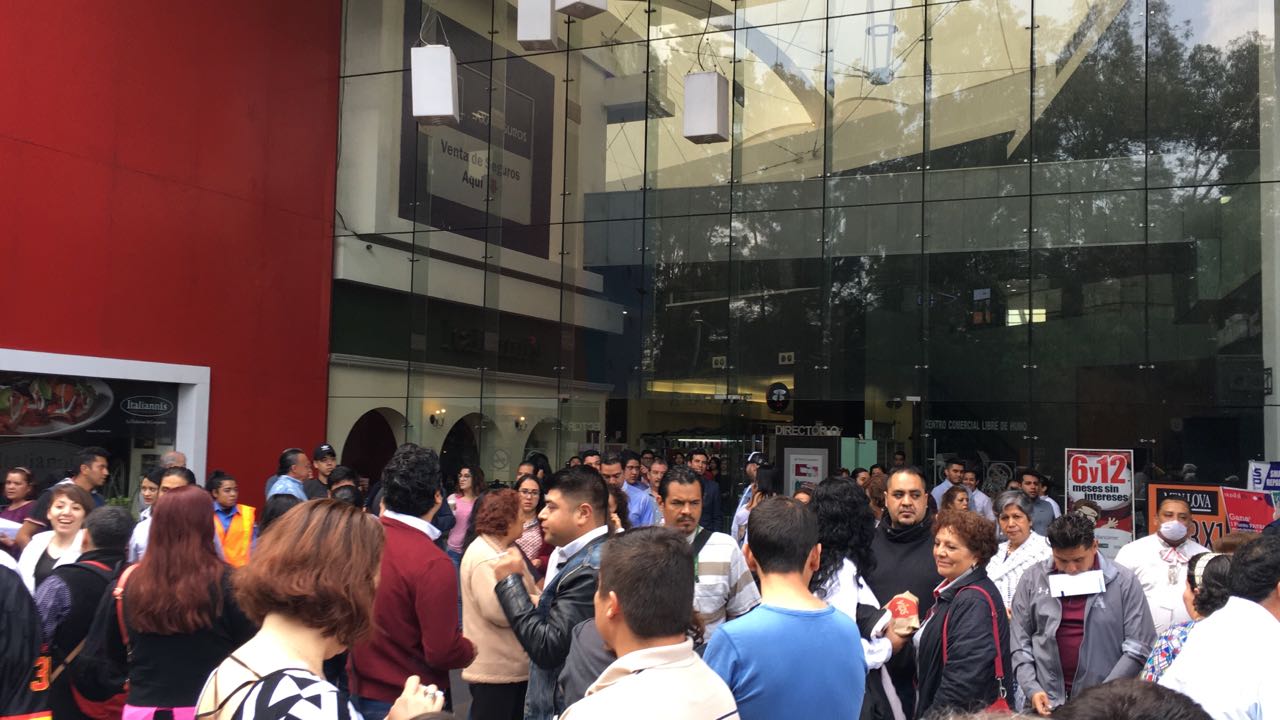 Personas salen de algunos edificios en avenida Churubusco y La Viga tras el simulacro del sismo de 1985.