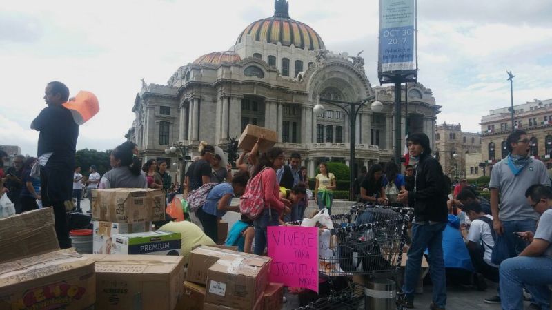 Jóvenes pasan víveres de mano en mano frente al Palacio de Bellas Artes.