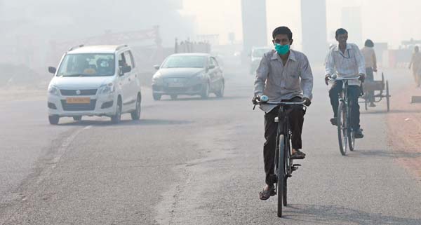 Un hombre utiliza mascarilla mientras circula en bicicleta en Nueva Delhi, India, uno de los países con más polución.
