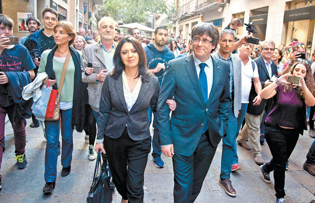 Carles Puigdemont y su esposa, Marcela Topor, ayer en las calles de Girona. 