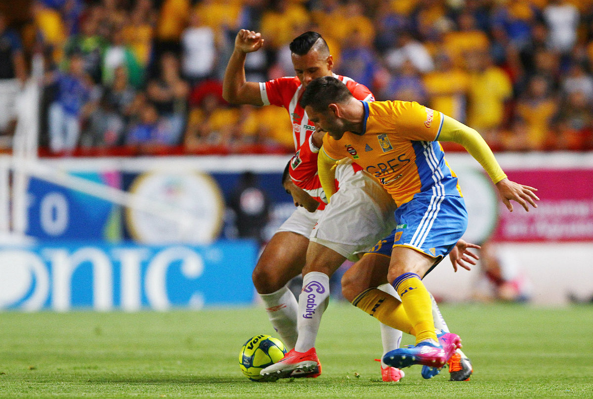 Mario de Luna y André-Pierre Gignac pelean un balón