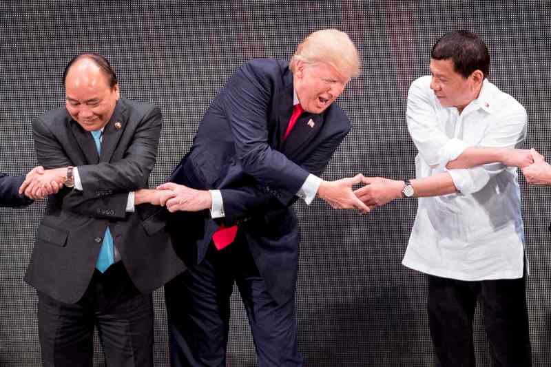 Trump durante el saludo tradicional en la cumbre ASEAN con el primer ministro de Vietnam, Nguyen Xuan Phuc (izq.) y el presidente de Filipinas, Rodrig