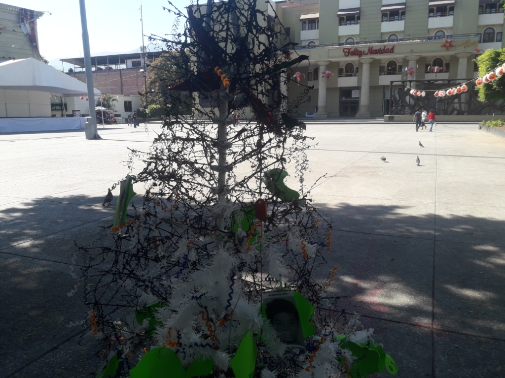 El árbol estaba adornado con imágenes de los rostros de los 43 normalistas.