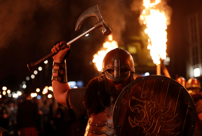 Vikingos Helly Aa de las Islas Shetland sostienen hachas y antorchas para marcar el comienzo de las celebraciones de Año Nuevo en Edimburgo, Escocia. 