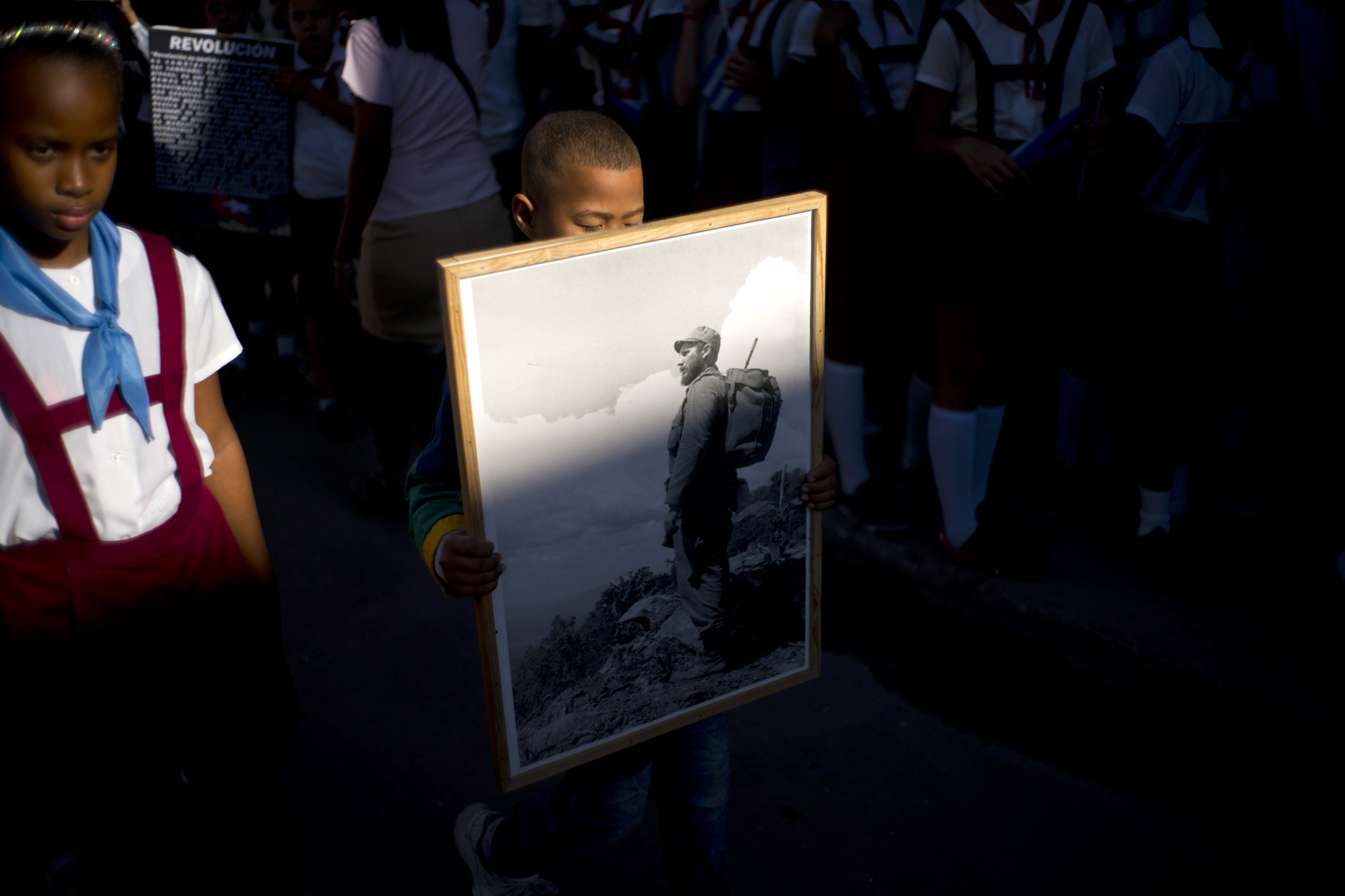 Un niño carga un retrato de Fidel Castro hace 59 años durante la Revolución de Cuba.