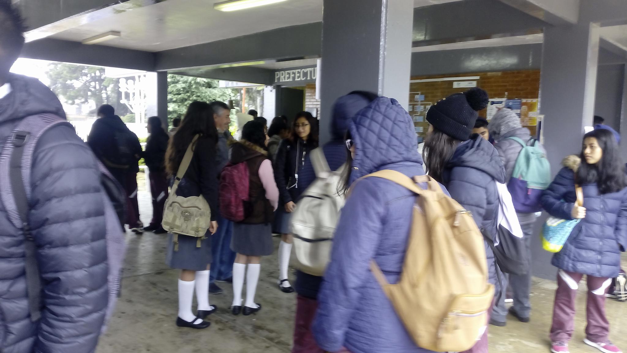 Alumnos del CBTIS 86 de Huauchinango esperan en los pasillos de la institución durante el paro de labores de profesores.