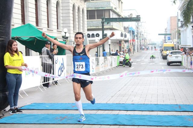 Corredores cruzan la meta del medio maratón.