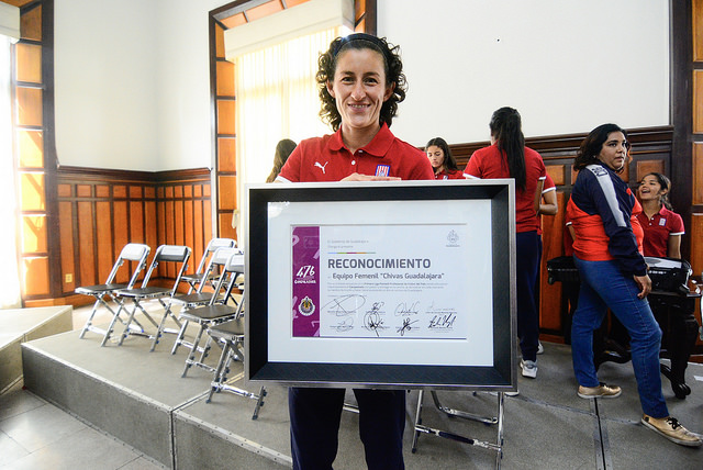La capitana del equipo, Tania Morales, sosteniendo el reconocimiento.
