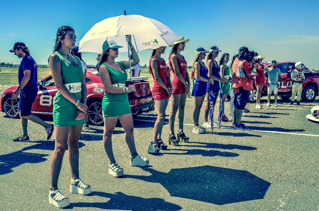 Mariana sostiene una sombrilla en un evento de carros en Argentina 