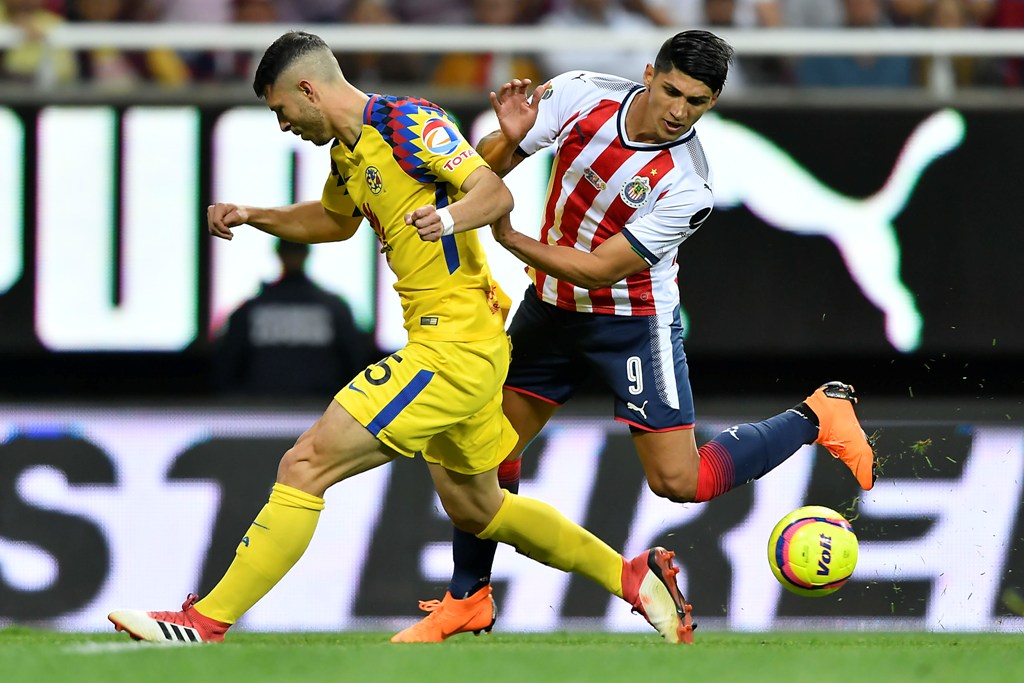 Alan Pulido en disputa por el balón 