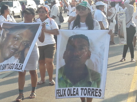 Algunas mujeres caminan con la fotografía de sus seres queridos durante la marcha.