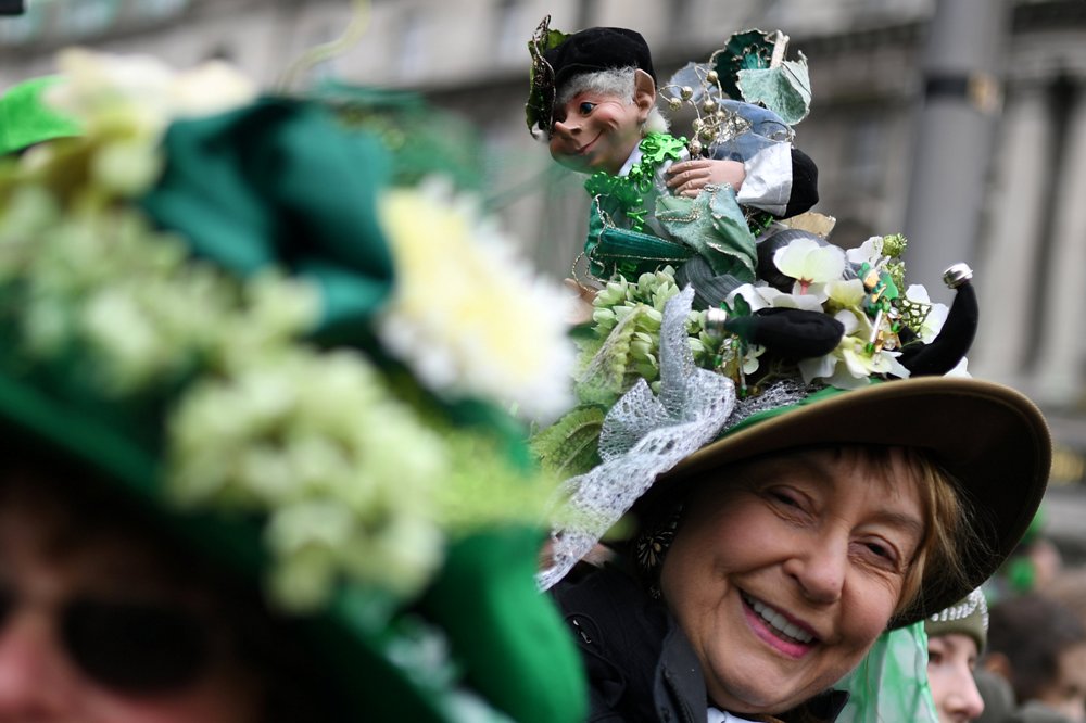 Una mujer luce un vistoso sombrero mientras observa el desfile del Día de San Patricio en Dublín.