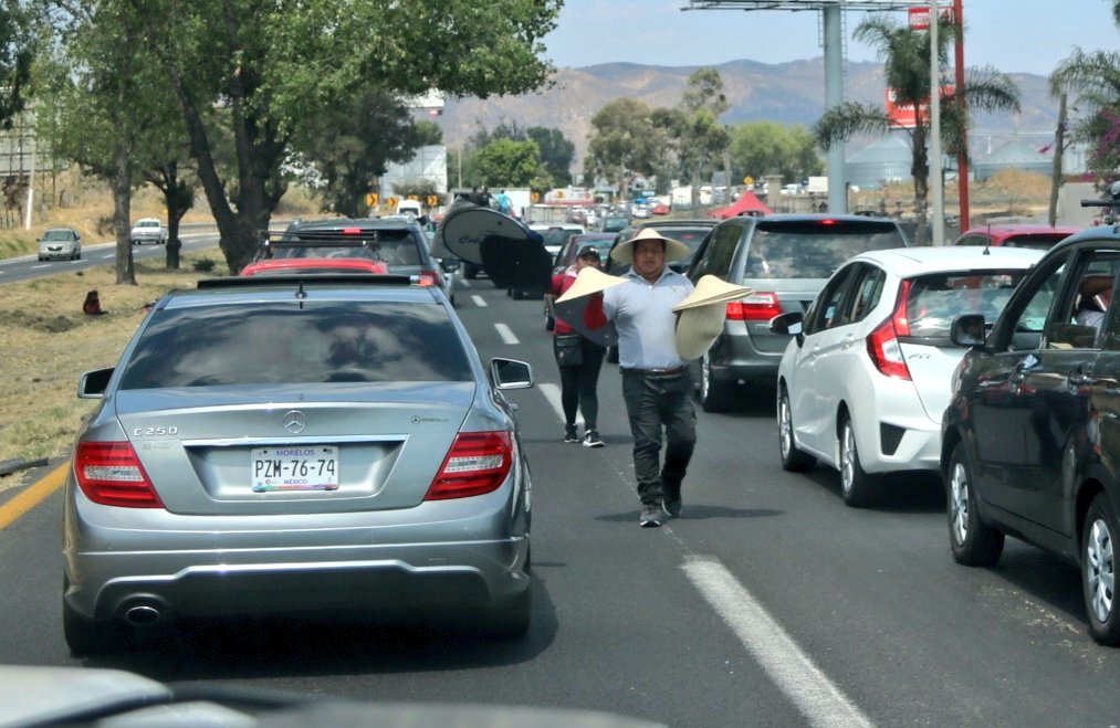 Comerciantes ofrecen productos a los automovilistas que salen de Guadalajara.