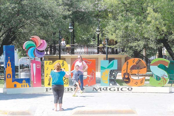 Algunos viajeros aprovechan las letras monumentales para tomarse fotografías como recuerdo de su visita.
