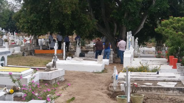 Momento en que agentes periciales llevan a cabo exhumación del cuerpo del bebé.