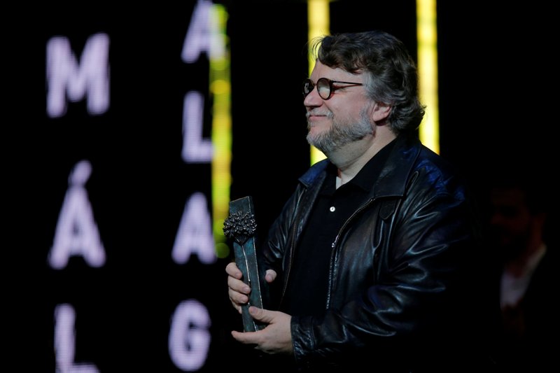 Guillermo del Toro sostiene el Premio Málaga que recibió de manos de Marisa Paredes y Ron Perlman.