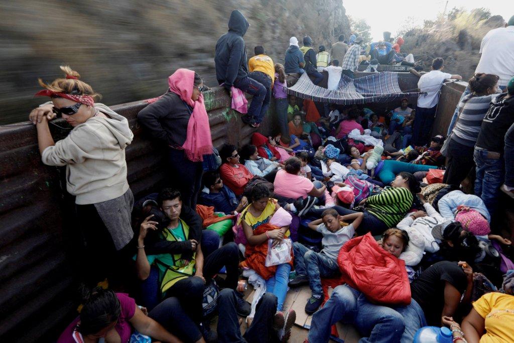 Los migrantes centroamericanos, que se desplazan en una caravana por México, viajan en un vagón abierto de un tren de carga.