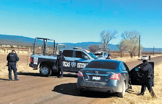 Policías revisan el auto en que fue ultimado el activista Juan Gutiérrez. 