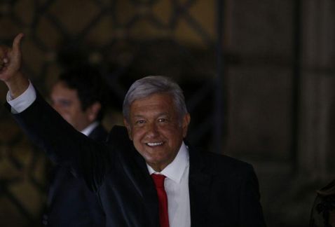 AMLO levanta la mano al llegar al Palacio de Minería para el primer debate presidencial.
