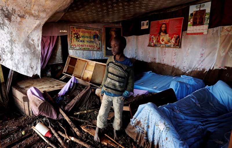 Un niño camina entre los escombros de su casa destruida por el agua, tras del desbordamiento de una represa en Kenia. (Reuters)